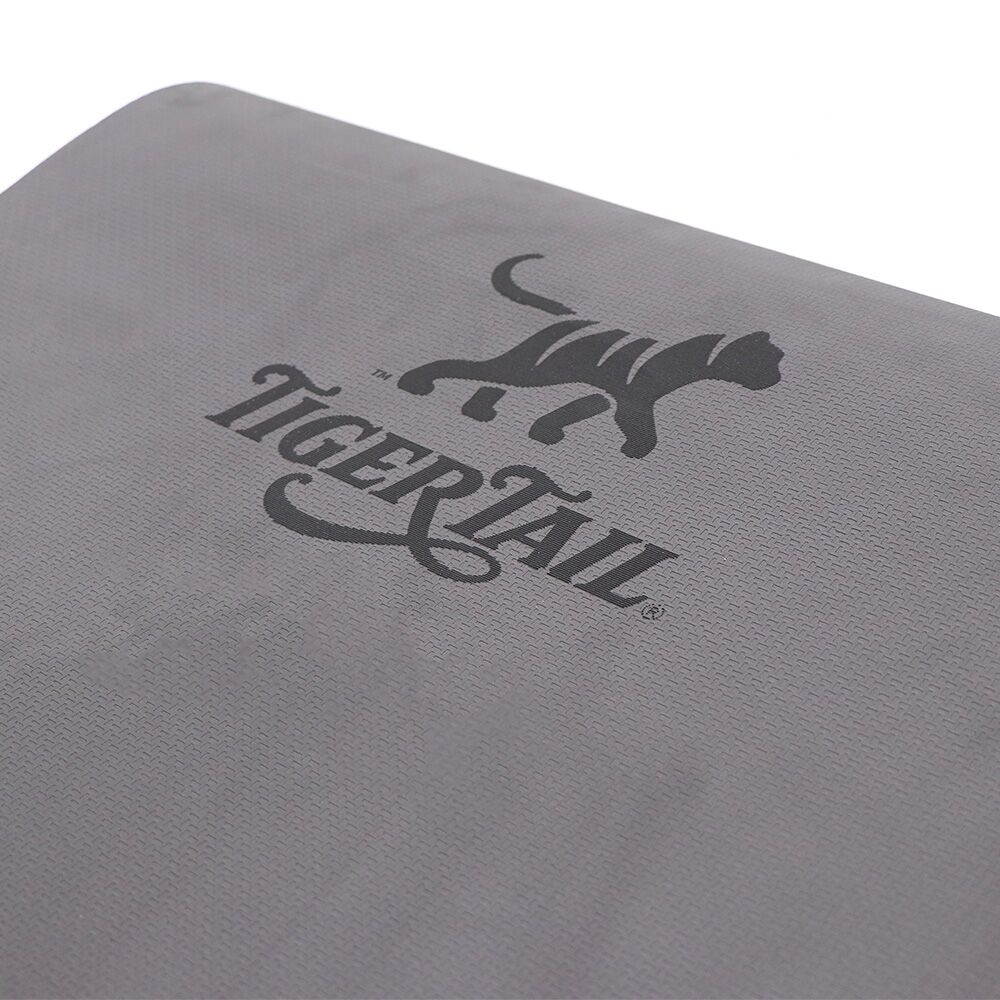 Top-down view of a gray, medium-density foam yoga mat, featuring a subtle non-slip textured surface.