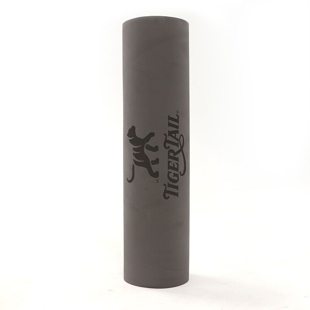 A rolled gray, medium-density foam yoga mat.