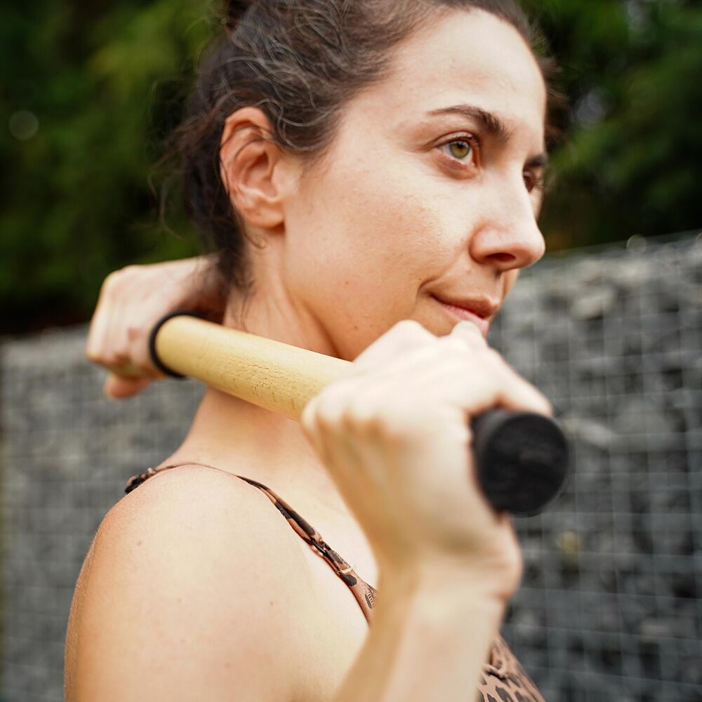 Woman Rolling her neck with ReGreen The Original 18" Wood Roller Massage Stick