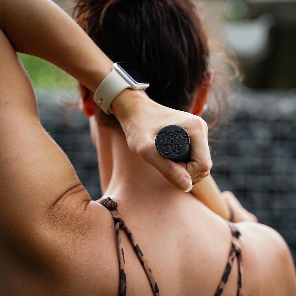 Woman Rolling her shoulder with ReGreen The Original 18" Wood Roller Massage Stick